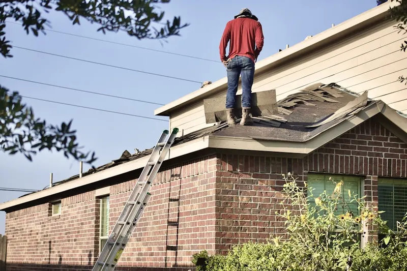 Professional roofer working on a residential roof in Deans